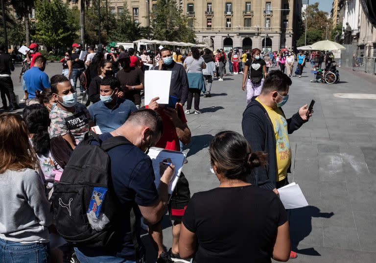 Largas filas de migrantes cerca de la Catedral de Santiago para regularizar la situación legal