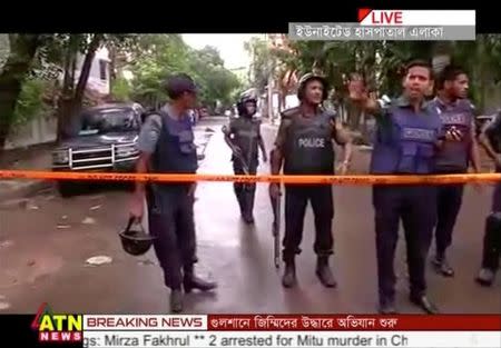 Police seen behind a cordon as security forces try to free hostages after gunmen stormed the Holey Artisan restaurant and took hostages early on Saturday, in Dhaka, Bangladesh in this still frame taken from video July 2, 2016. Courtesy of ATN News /via REUTERS TV