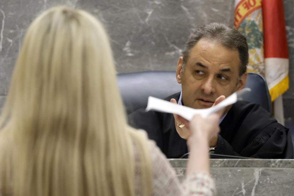 Assistant State Attorney Alixandra Buckelew hands a document to Judge Michael Usan before the start of the fourth day of jury deliberations in the XXXTentacion murder trial at the Broward County Courthouse in Fort Lauderdale on Monday, March 13, 2023. Emerging rapper XXXTentacion, born Jahseh Onfroy, 20, was killed during a robbery outside of Riva Motorsports in Deerfield Beach in 2018 allegedly by defendants Michael Boatwright, Trayvon Newsome, and Dedrick Williams. (Amy Beth Bennett/South Florida Sun-Sentinel via AP, Pool)