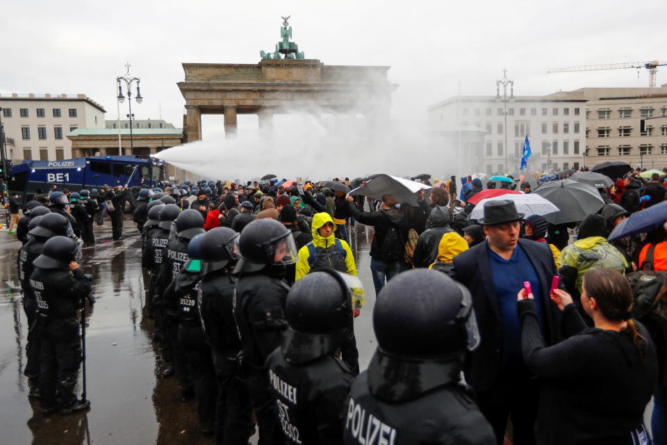 Demonstrators are sprayed with a water cannon during a protest against the government's coronavirus disease (COVID-19) restrictions, next to the Brandenburg Gate in Berlin, November, 18, 2020. / Credit: FABRIZIO BENSCH / REUTERS