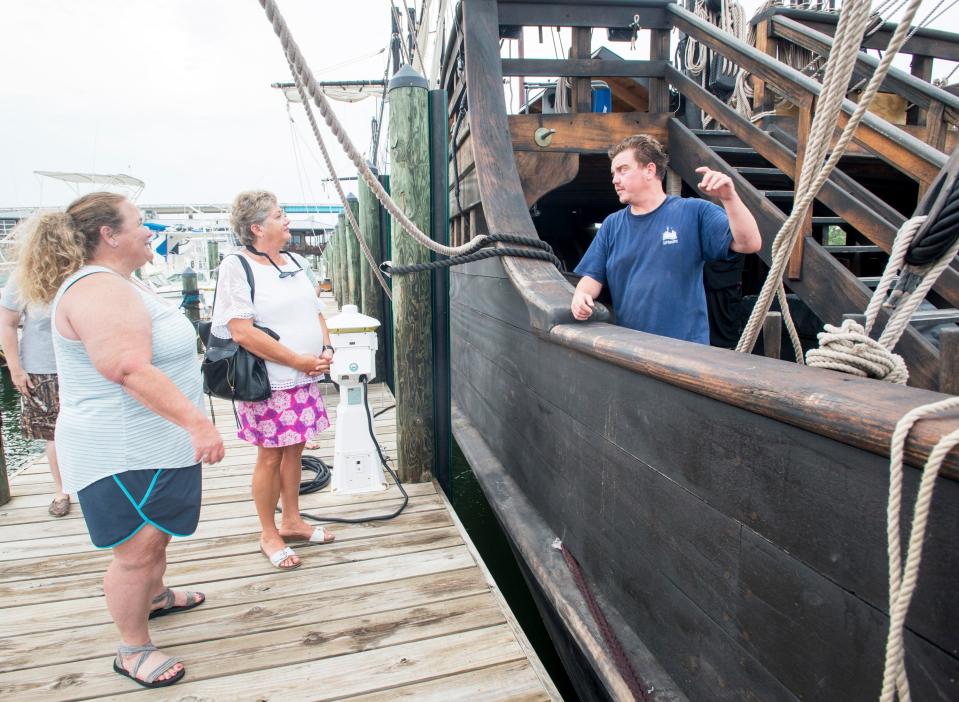 Crew member Jamie Durant, of Newport, Rhode Island, right, chats with Angel Robertson, of Ethel, Louisiana, left, and Kathy Fee, of Perdido Key, while preparing the replica of Christopher Columbus' Pinta ship for visitors at the Perdido Key Oyster Bar and Restaurant dock on Tuesday, June 5, 2018.