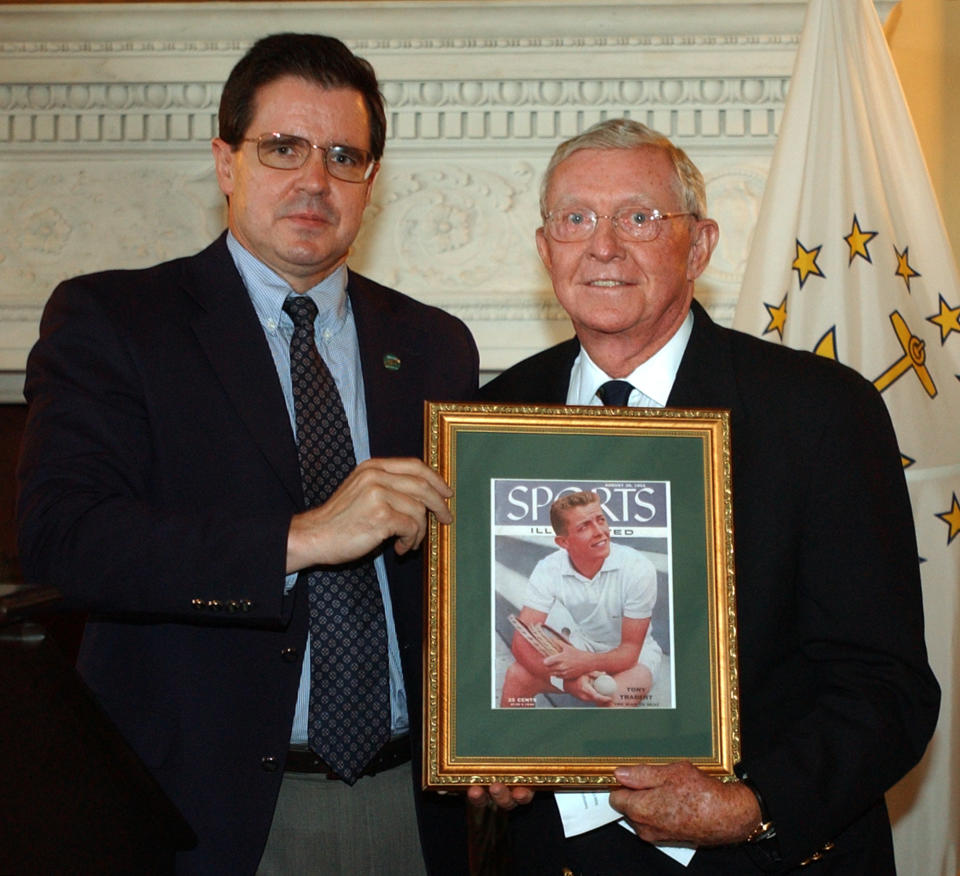 FILE - International Tennis Hall of Fame CEO Mark Stenning, left, presents Hall of Fame president and 1970 Hall of Famer Tony Trabert with a framed Sports Illustrated cover featuring Trabert after his French Open win, at the Statehouse in Providence, R.I., in this June 7, 2004, file photo. Trabert, a five-time Grand Slam singles champion and former No. 1 player who went on to successful careers as a Davis Cup captain, broadcaster and executive, has died. He was 90 years old. The Tennis Hall of Famer's death Wednesday night, Feb. 3, 2021, at his home in Ponte Vedra Beach, Florida, was confirmed by his daughter, Brooke Trabert Dabkowski. (AP Photo/Victoria Arocho, File)