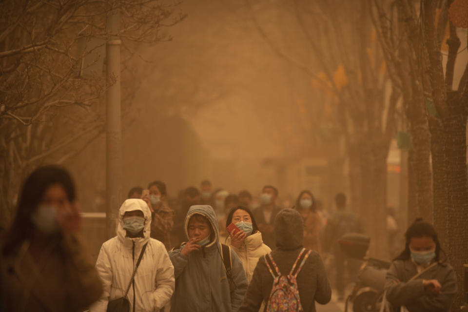 <p>Varias personas caminan por Pekín durante la peor tormenta de arena que ha vivido la ciudad en una década. Las imágenes parecen sacadas de un escenario de ciencia ficción. (AP Photo/Mark Schiefelbein)</p> 