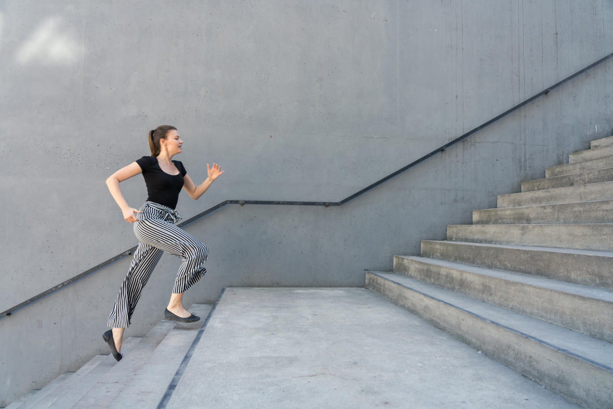 Woman running up steps in urban setting