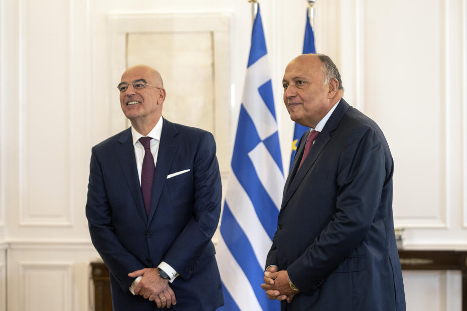 Egyptian foreign minister Sameh Shoukry, right, and his Greek counterpart Nikos Dendias stand before their meeting with Greek Prime Minister, in Athens, on Tuesday, April 11, 2023. Greece and Egypt have close military ties and are planning to build an undersea electricity grid connector across the Mediterranean. (AP Photo/Petros Giannakouris)