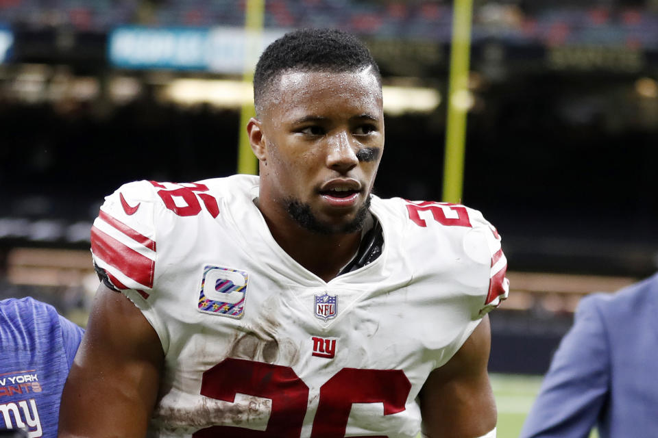 FILE - In this Sunday, Oct. 3, 2021, file photo, New York Giants running back Saquon Barkley (26) walks off the field after an NFL football game against the New Orleans Saints in New Orleans. The talented fourth-year running back is probably going to miss at least a game or two after spraining his left ankle on a fluke play early in the Giants 44-20 loss to the Dallas Cowboys on Sunday. (AP Photo/Tyler Kaufman, File)