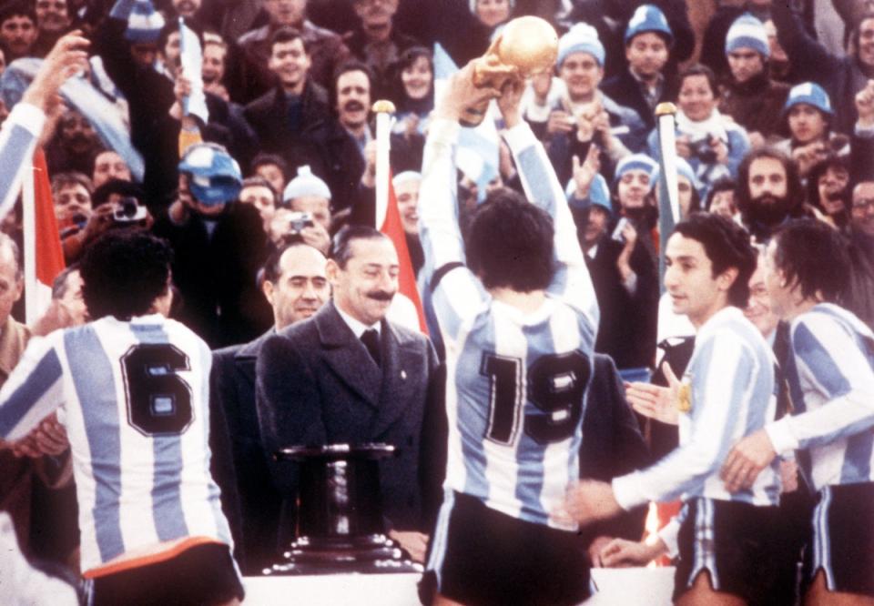 Jorge Videla presents the World Cup to captain Daniel Passarella after Argentina beat Holland 3-1 in the final (AP)