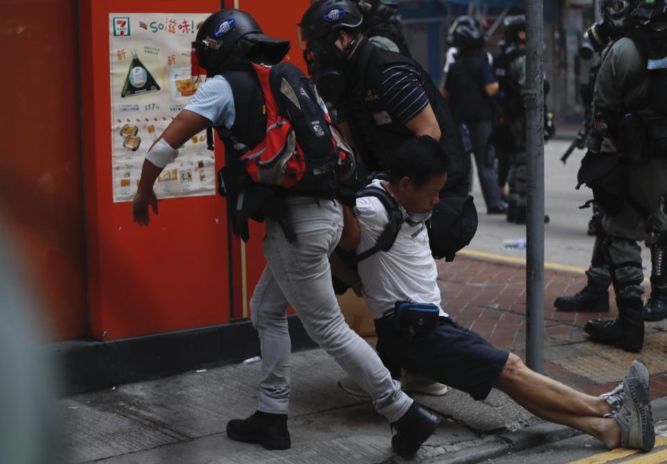 An injured anti-government protester is attended to by others during a clash with police in Hong Kong, Tuesday, Oct. 1, 2019. Thousands of black-clad protesters marched in central Hong Kong as part of multiple pro-democracy rallies Tuesday urging China's Communist Party to "return power to the people" as the party celebrated its 70th year of rule. (AP Photo/Gemunu Amarasinghe )