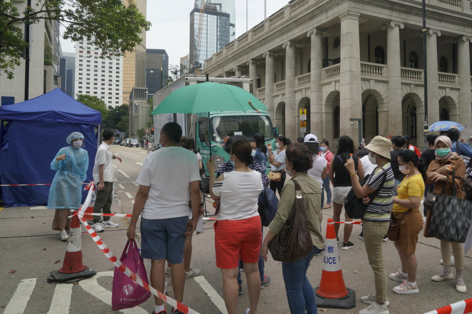 In this Saturday, May 1, 2021, photo, domestic helpers from the Philippines line up at the temporary testing center for COVID-19, in Hong Kong. Hong Kong officials have dropped a plan to make it mandatory for foreign domestic workers to be vaccinated against the coronavirus, after the move drew criticism that it was discriminatory. (AP Photo/Kin Cheung)