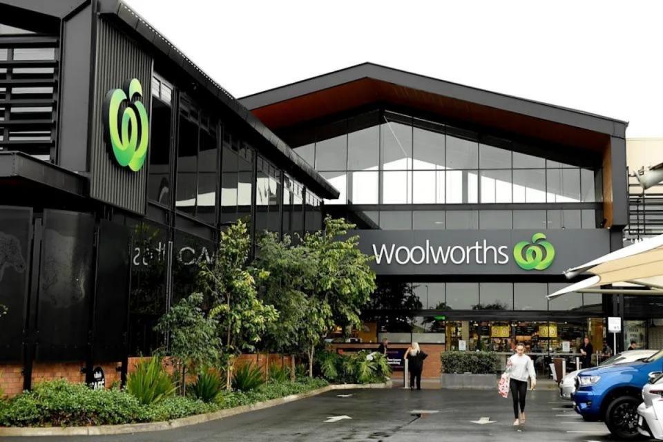 Woolworths shoppers exit supermarket with grocery bags