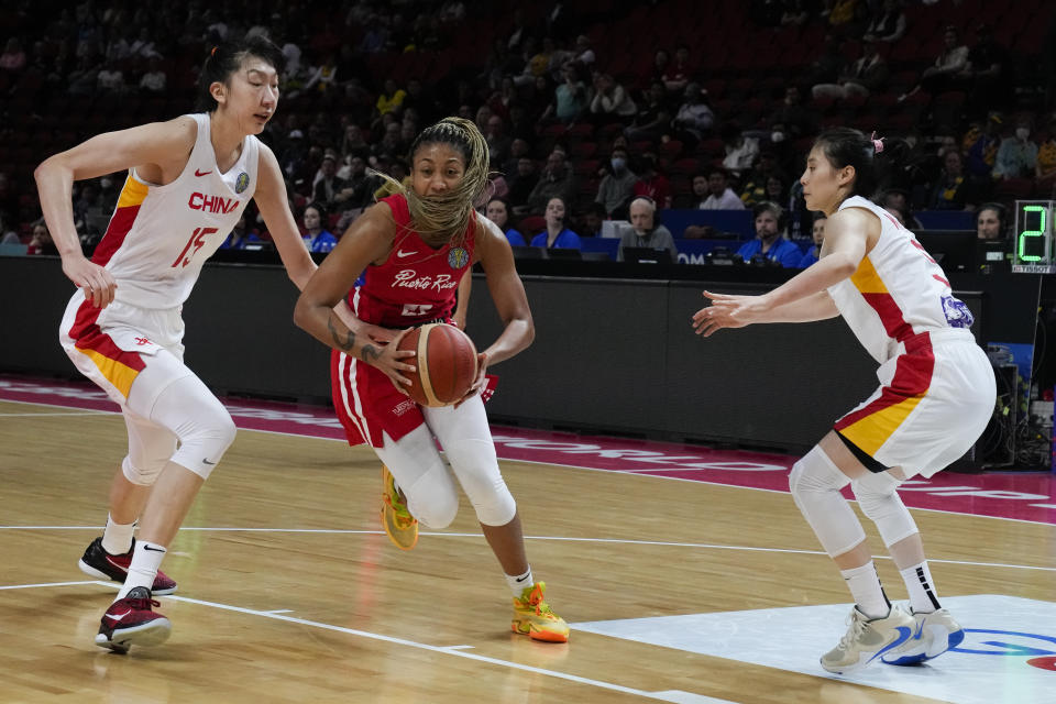 Puerto Rico's Arella Guirantes runs between China's Han Xu, left, and Wang Siyu, right, during their game at the women's Basketball World Cup in Sydney, Australia, Monday, Sept. 26, 2022. (AP Photo/Mark Baker)