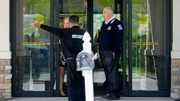 PHOTO: Security and staff personnel mill around The Crossroads Hotel where two busloads of migrants arrived hours earlier, Thursday, May 11, 2023, in Newburgh, N.Y. (John Minchillo/AP)