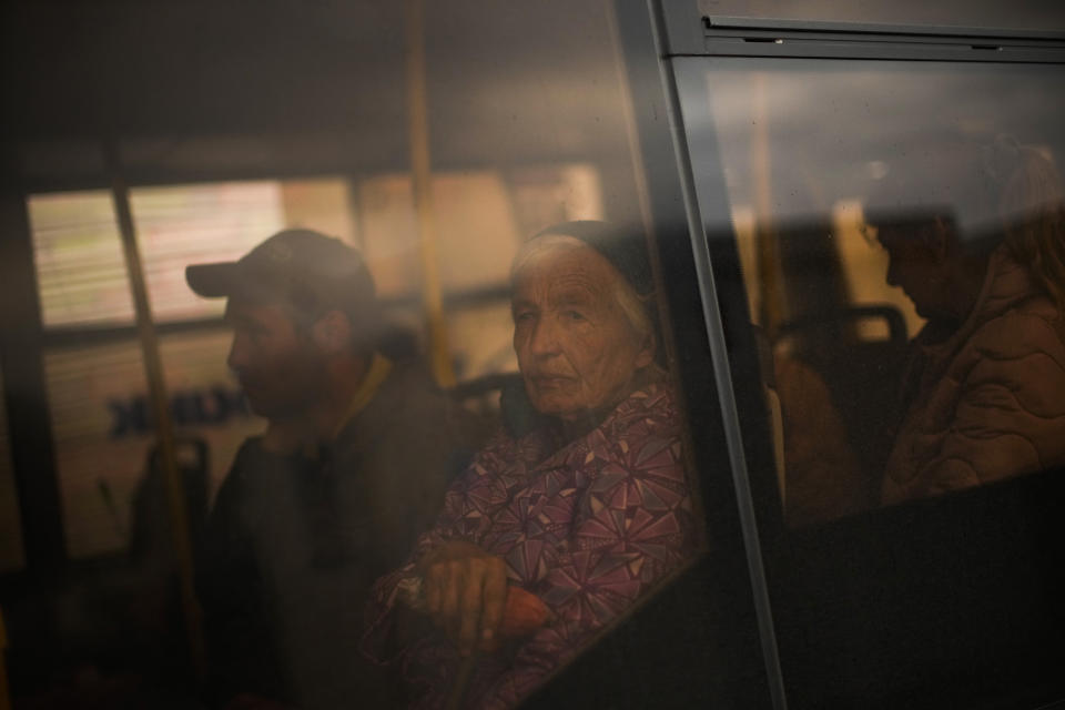 Kateryna Hodza, 85, and her grandson Dorschenko take a bus from a reception center for displaced people in Zaporizhzhia, Ukraine, Friday, April 29, 2022. They fled from Mala Tokmachka, in Zaporizhzhia region, as thousands of Ukrainian continue to leave Russian occupied areas. (AP Photo/Francisco Seco)