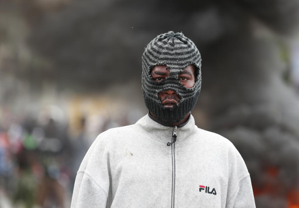 A masked demonstrator joins a protest calling for the resignation of President Jovenel Moise, in Port-au-Prince, Haiti, Friday, Oct. 4, 2019. After a two-day respite from the recent protests that have wracked Haiti's capital, opposition leaders urged citizens angry over corruption, gas shortages, and inflation to join them for a massive protest march to the local headquarters of the United Nations.(AP Photo/Rebecca Blackwell)