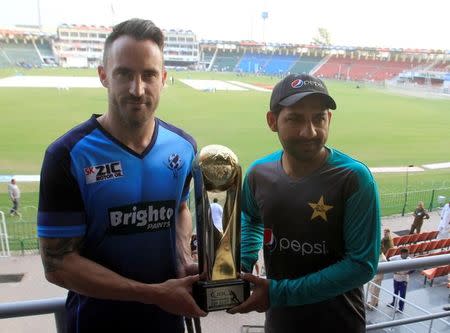 Team captain Sarfraz Ahmed of Pakistan and International World XI captain Faf du Plessis hold the Independence Cup trophy at the Gaddafi Cricket Stadium in Lahore, Pakistan September 11, 2017. REUTERS/Mohsin Raza/Files