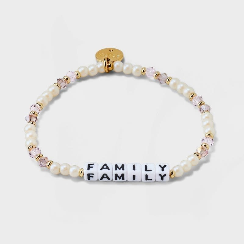 the bracelet in pearl and crystal with brass hardware and beads that read "family"