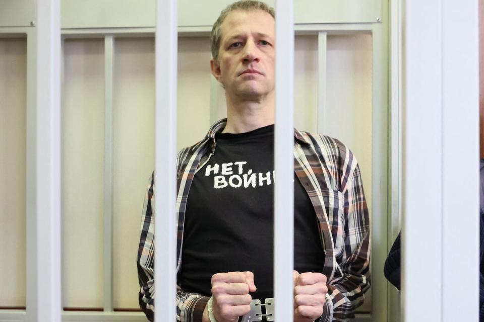 Russian journalist Roman Ivanov, wearing a T-shirt that says ‘No war,’ stands inside a defendants’ cage (AFP/Getty)