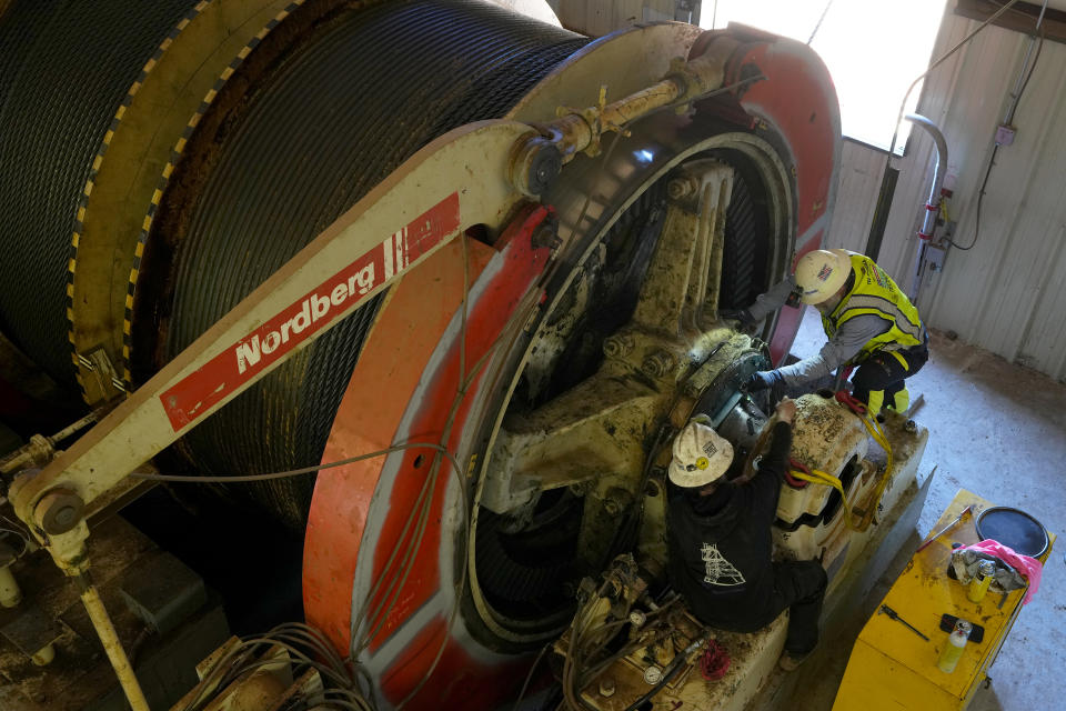 Workers perform routine maintenance on a mining winch at the Energy Fuels Inc. uranium Pinyon Plain Mine Wednesday, Jan. 31, 2024, near Tusayan, Ariz. The largest uranium producer in the United States is ramping up work just south of Grand Canyon National Park on a long-contested project that largely has sat dormant since the 1980s. (AP Photo/Ross D. Franklin)