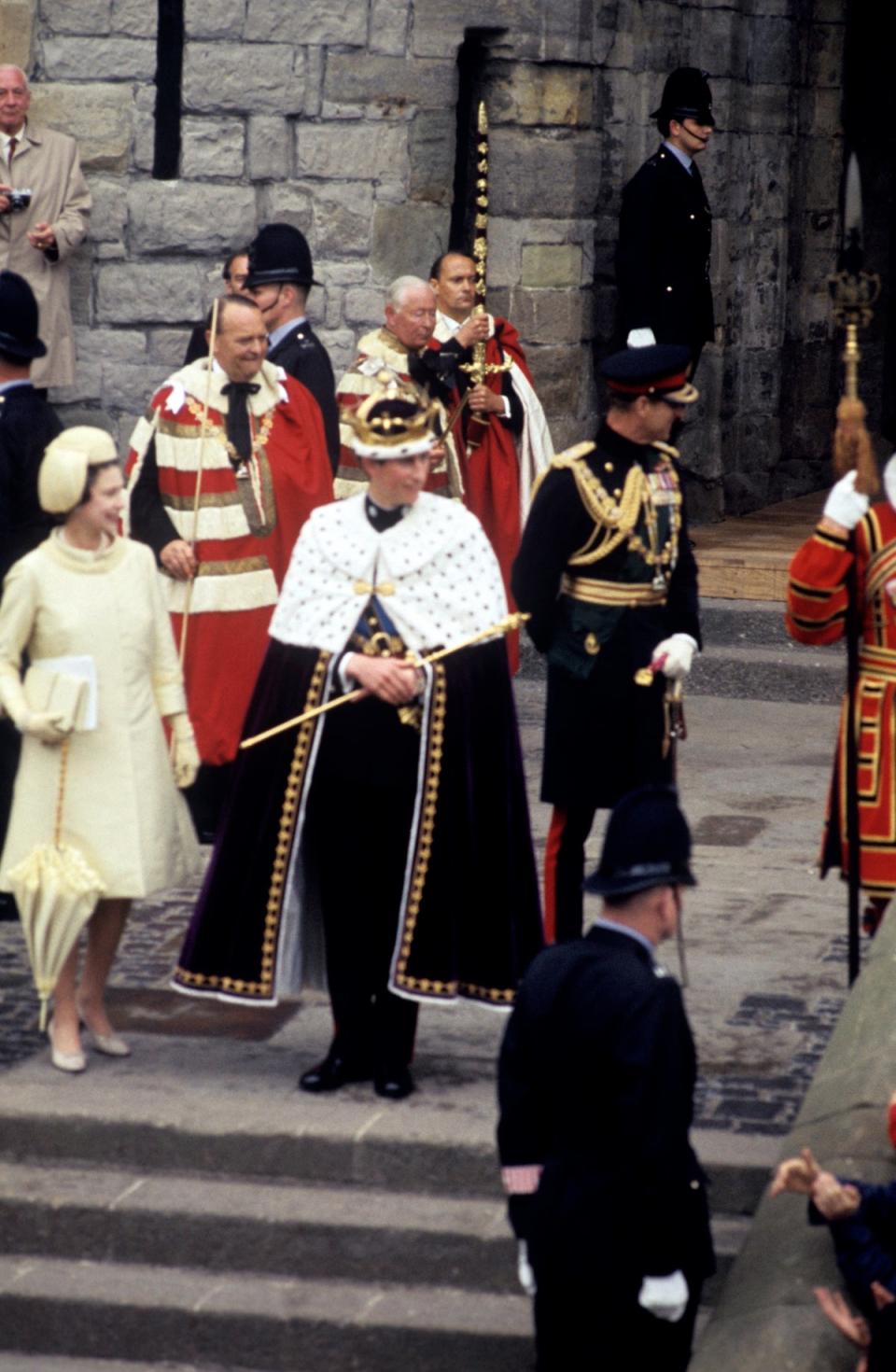 The Queen presents her son, Prince Charles, the Prince of Wales at the King's Gate at Caernarfon Castle after his investiture (PA )