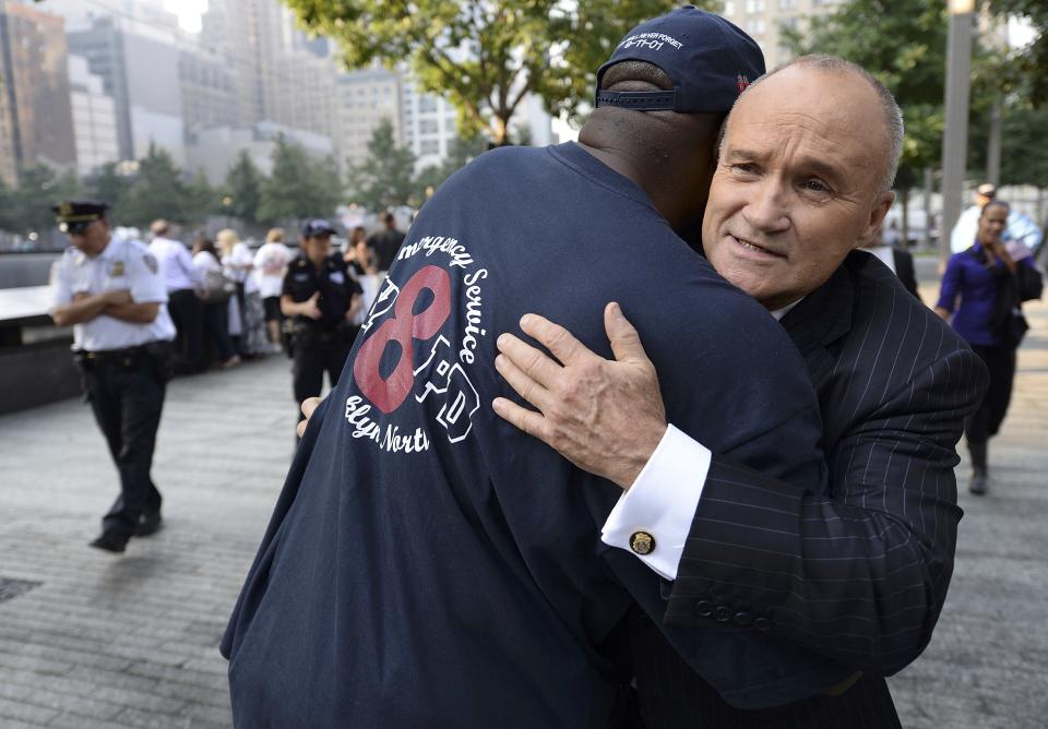 Ray Kelly (R), New York City Police Department Commissioner, hugs a friend at the South reflecting pool at the 9/11 Memorial during ceremonies marking the 12th anniversary of the 9/11 attacks on the World Trade Center in New York, September 11, 2013. (REUTERS/Stan Honda)