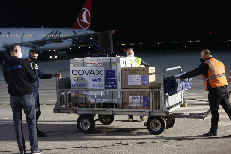 FILE - In this Sunday, March 28, 2021 file photo, airport personal unload the first batch of the AstraZeneca vaccines sent from the Covax facility, at Adem Jashari airport Pristina, Kosovo which is the last country in the continent yet to start inoculations. In late June, the international system for sharing coronavirus vaccines sent about 530,000 doses to Britain – more than double the amount sent that month to the entire continent of Africa. It was the latest example of how a system that was supposed to guarantee low and middle-income countries vaccines is failing, leaving them at the mercy of haphazard donations from rich countries. (AP Photo, file)