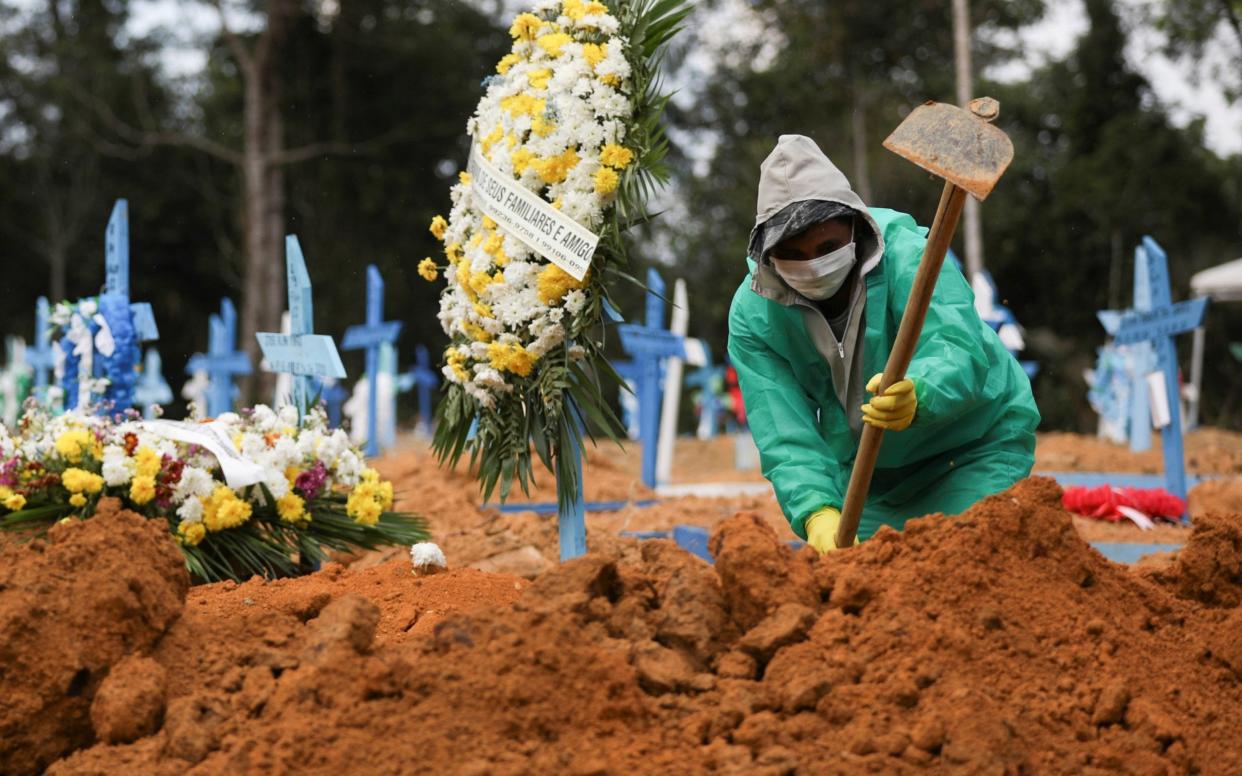 A gravedigger works during a funeral at the Parque Taruma cemetery in Manaus, Brazil - BRUNO KELLY / Reuters 