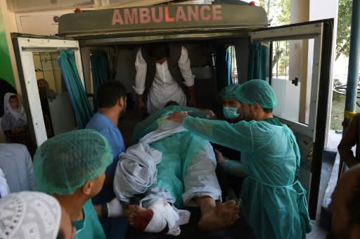 A wounded Afghan man is taken out of an ambulance at the Wazir Akbar Khan hospital following a bomb blast in Kabul