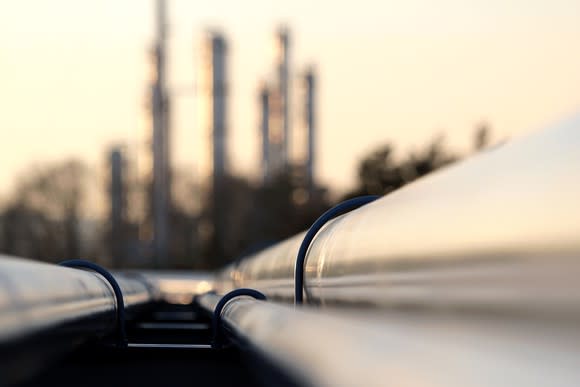 Pipelines connected to an oil refinery in the distance.