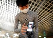 An employee of online fashion retailer Zozo Inc. demonstrates the company's Zozosuit 2, a 3D body measurement suit, in Tokyo