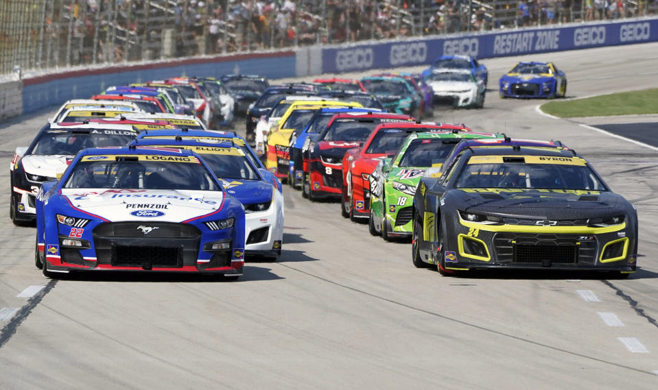 Joey Logano (22) and William Byron (24) lead the pack on a restart during the NASCAR Cup Series auto race at Texas Motor Speedway in Fort Worth, Texas, Sunday, Sept. 25, 2022. (AP Photo/Larry Papke)