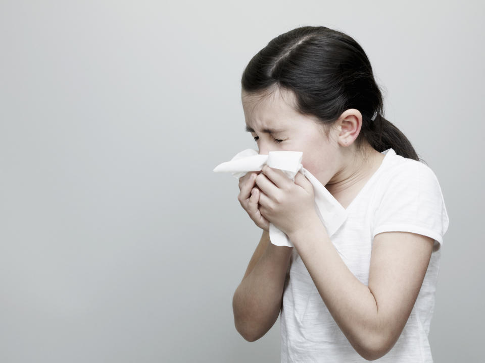 Young Girl Sneezing and Blowing Nose With Tissue.