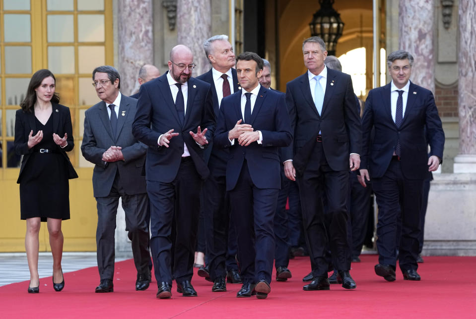 French President Emmanuel Macron, center, speaks with European Council President Charles Michel, center left, as they walk to a group photo at an EU summit at the Chateau de Versailles, in Versailles, west of Paris, Thursday, March 10, 2022. European Union leaders on Thursday will focus on how to help Ukraine in its war with Russia, but the measures discussed are expected to stop short of fulfilling the country's hopes it can soon join the bloc. (AP Photo/Michel Euler)
