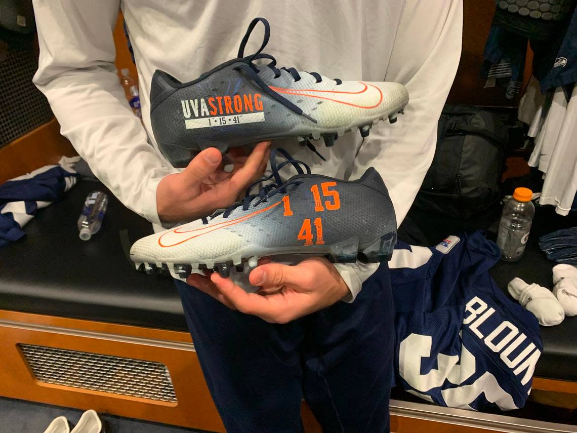 Seahawks rookie safety Joey Blount holds the special cleats he wore in Seattle’s game Nov. 27 to honor and remember Lavel Davis Jr., Devin Chandler and D’Sean Perry, three of Blount’s former University of Virginia teammates who were shot and killed on campus in Charlottesville Nov. 13, 2022.