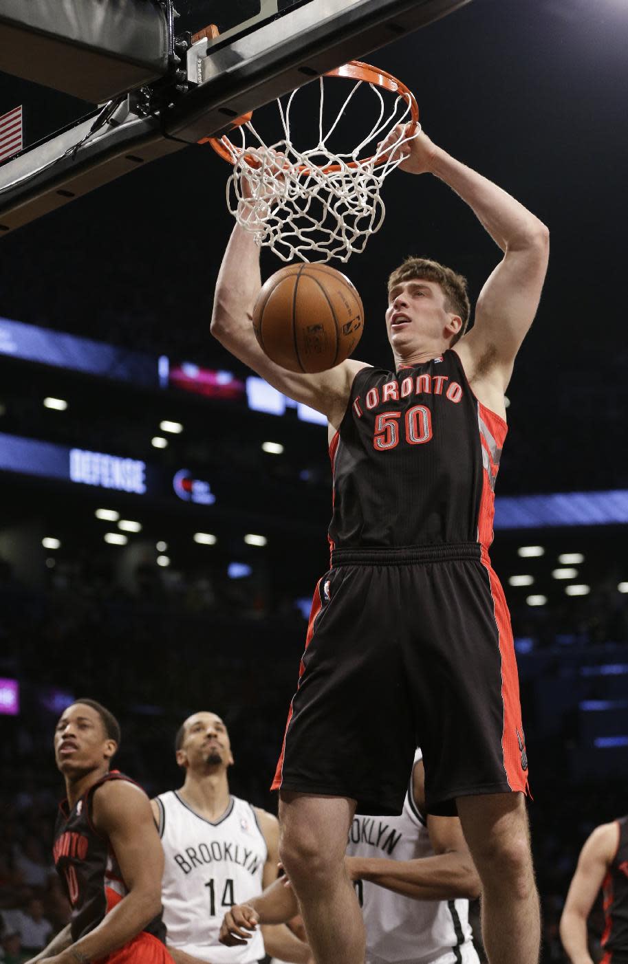 Toronto Raptors' Tyler Hansbrough (50) dunks as Brooklyn Nets' Shaun Livingston (14) watches during the first half of Game 3 of an NBA basketball first-round playoff series Friday, April 25, 2014, in New York. (AP Photo/Frank Franklin II)