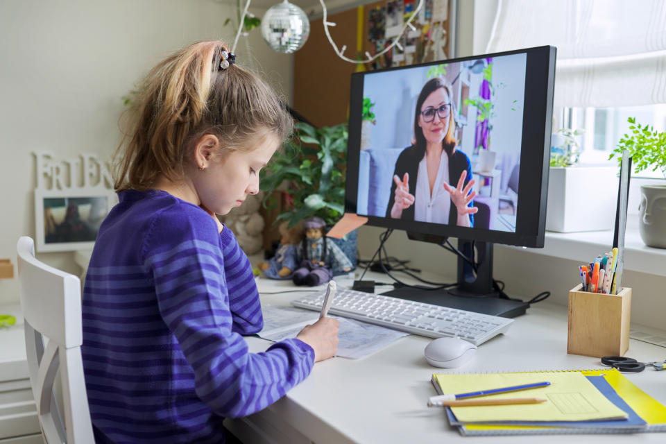 A young elementary girl on Zoom school at home