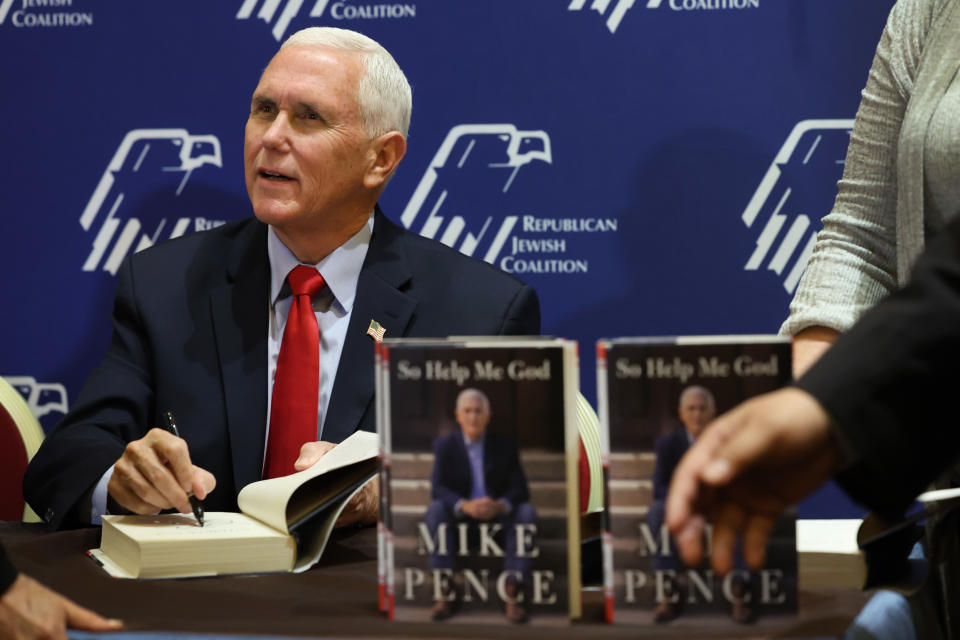 Former Vice President Mike Pence signs copies of his book