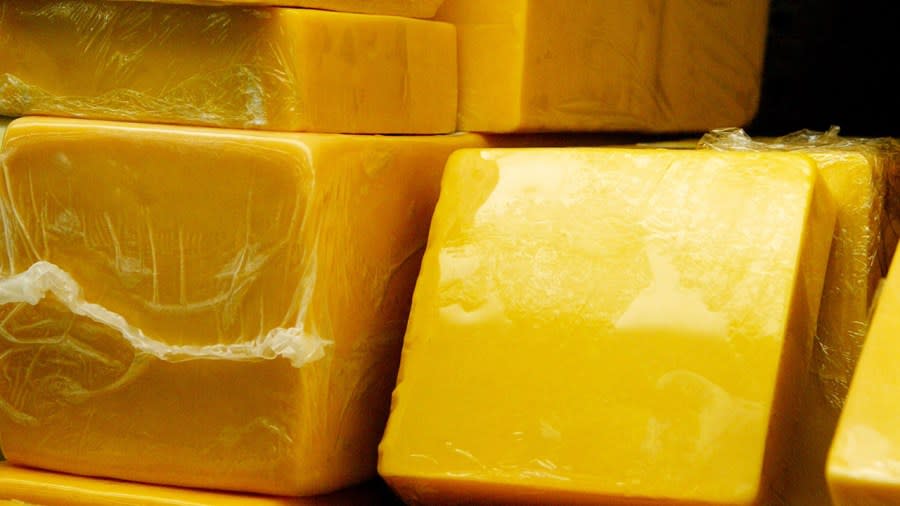 FILE: Blocks of cheddar cheese are displayed. (Photo by Tim Boyle/Getty Images)