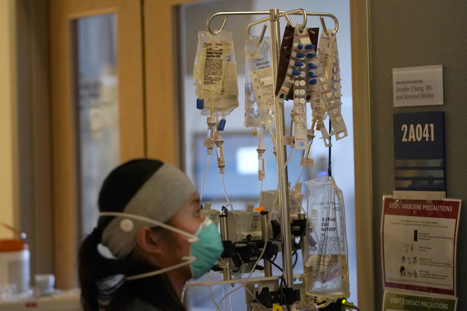 Clinical Nurse Radelle Liban works outside of rooms with COVID-19 patients in the intensive care unit at Santa Clara Valley Medical Center during the coronavirus pandemic in San Jose, Calif., Wednesday, Jan. 13, 2021. (AP Photo/Jeff Chiu)