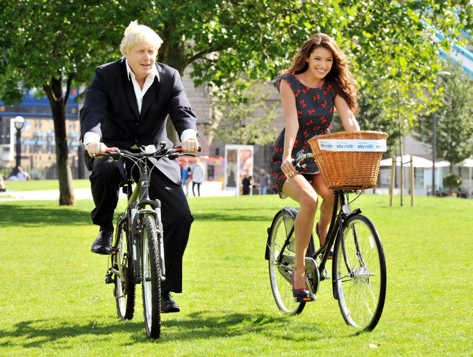 The Mayor of London Boris Johnson accompanied by Kelly Brook riding bicycles in central London to promote the London Skyride, this morning.