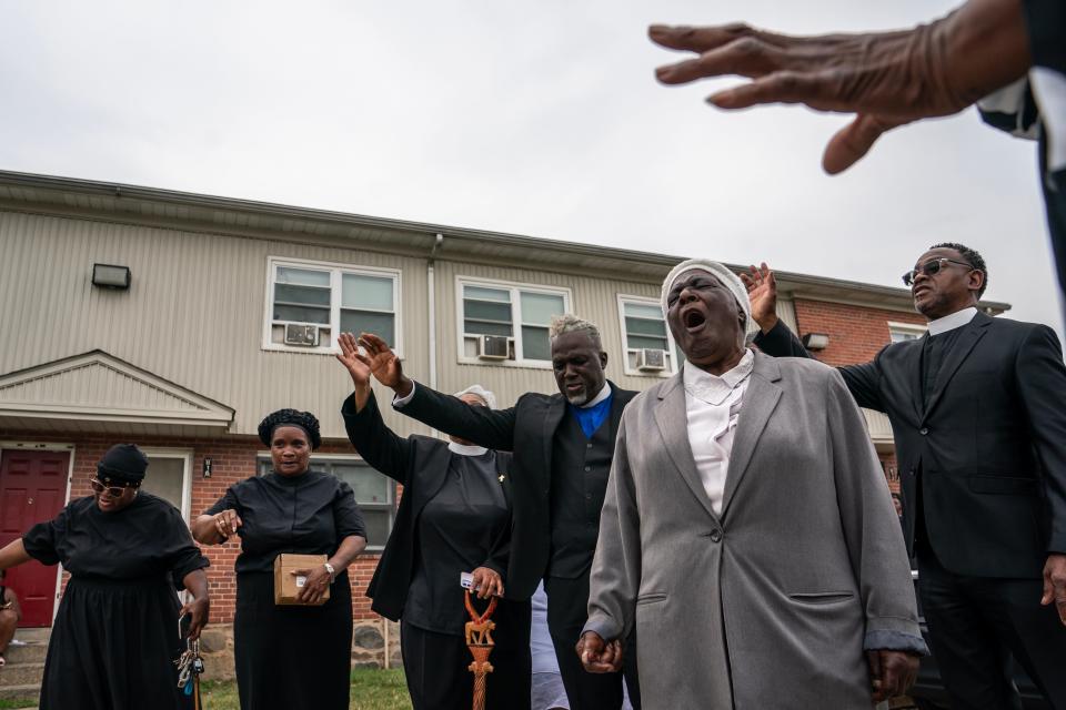 Worshippers with the Kingdom Life Church pray at the site of a mass shooting in the Brooklyn Homes neighborhood on July 2, 2023, in Baltimore.