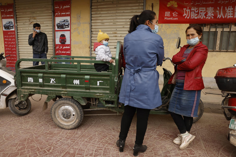 A child waits on a motor bike in Kashgar in western China's Xinjiang Uyghur Autonomous Region on Friday, March 19, 2021. Residents of a city in China’s far west Xinjiang region say they are experiencing hunger, forced quarantines and dwindling supplies of medicine and daily necessities after more than 40 days in a virus lockdown. (AP Photo/Ng Han Guan, File)