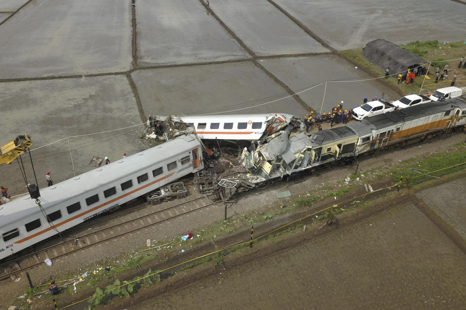 A crane tries to remove the wreckage after the collision between two trains in Cicalengka, West Java, Indonesia, Friday, Jan. 5, 2024. The trains collided on Indonesia's main island of Java on Friday, causing several carriages to buckle and overturn, officials said. (AP Photo/Achmad Ibrahim)