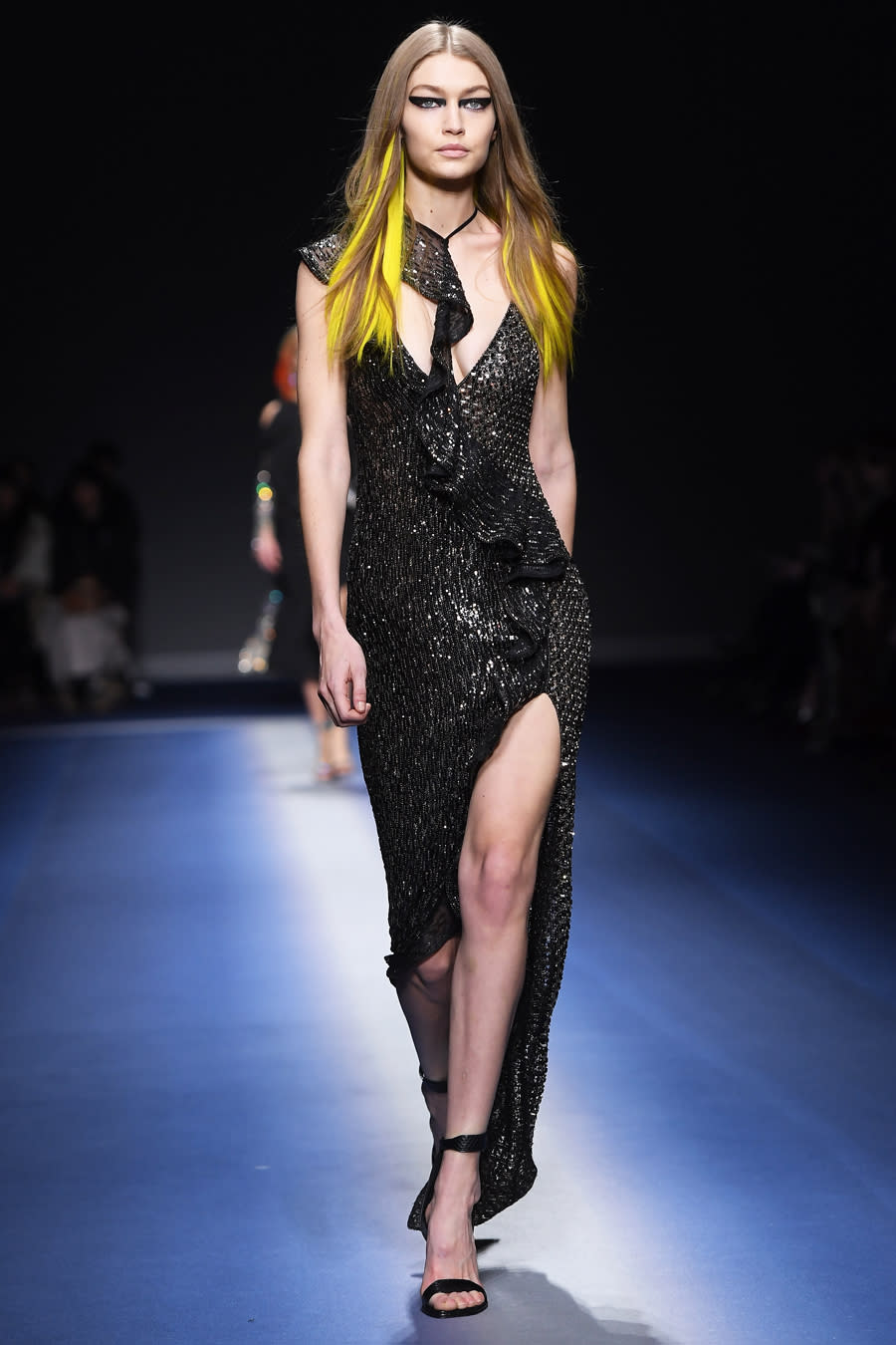 <p>The 21-year-old's blonde locks were filled out with neon yellow streaks at the Versace show in Milan. Hadid strut down the runway in a plunging black dress with a thigh-high slit.</p>