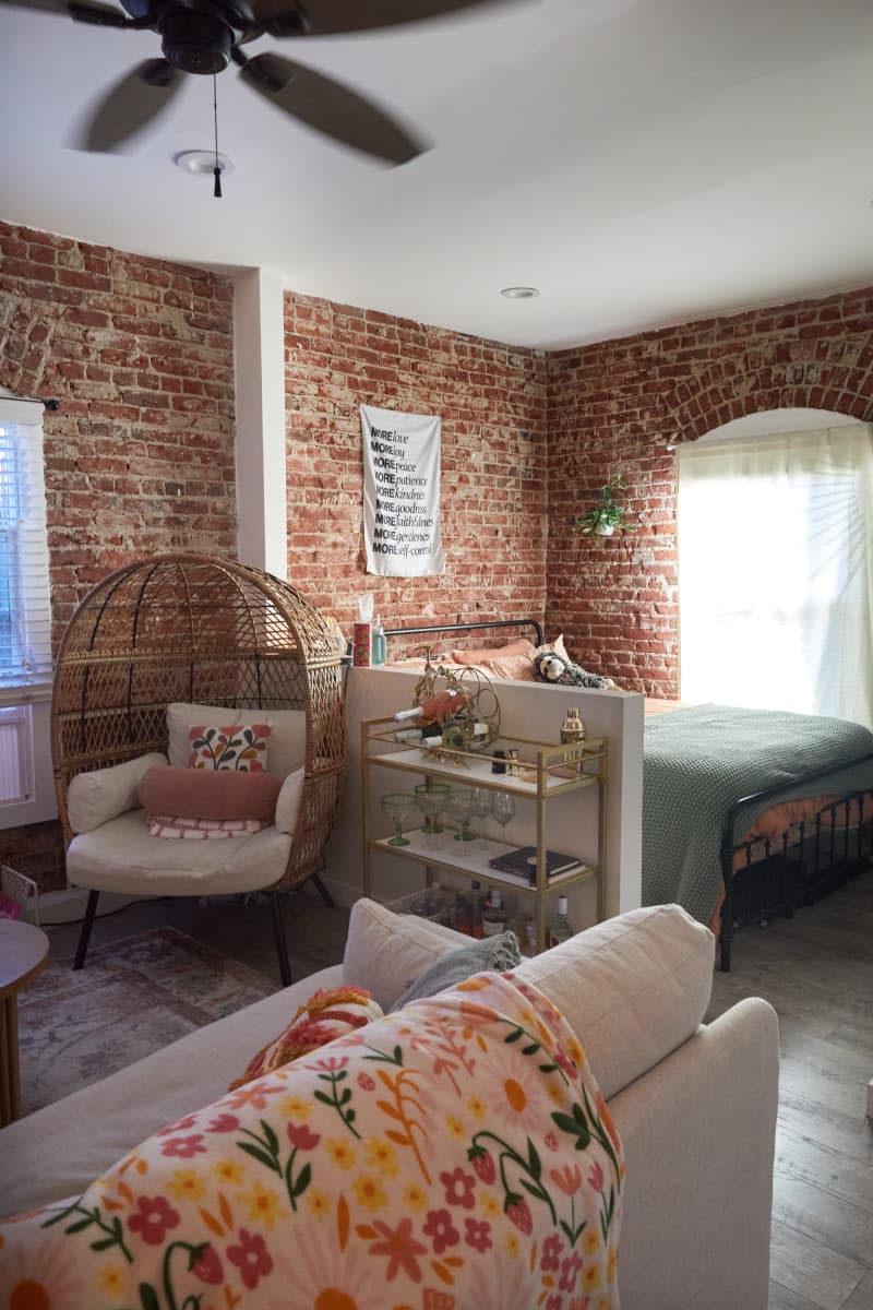 Living room with a small divider leading to a sleeping area.