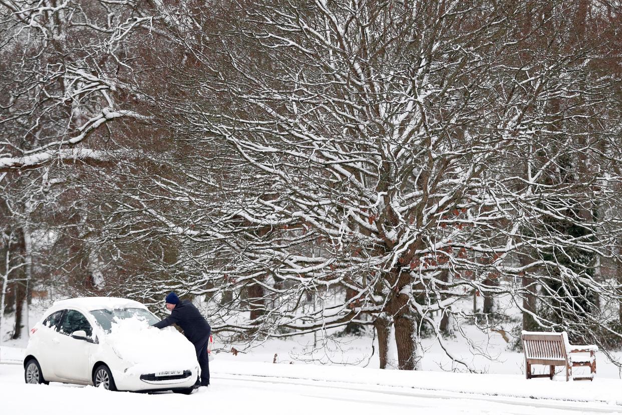 A motorist clears snow from the windscreen of a car in Hartley Wintney, in Hampshire, 40 miles west of London, on February 1, 2019. - Snowfall and icy conditions were expected Friday to cause travel disruption after temperatures overnight reached as low as minus 15.4C. An amber snow warning has been issued for an area west of London including parts of Oxfordshire, Hampshire and Buckinghamshire, after as much as 14cm of snow fell on south-west England. (Photo by Adrian DENNIS / AFP)        (Photo credit should read ADRIAN DENNIS/AFP via Getty Images)