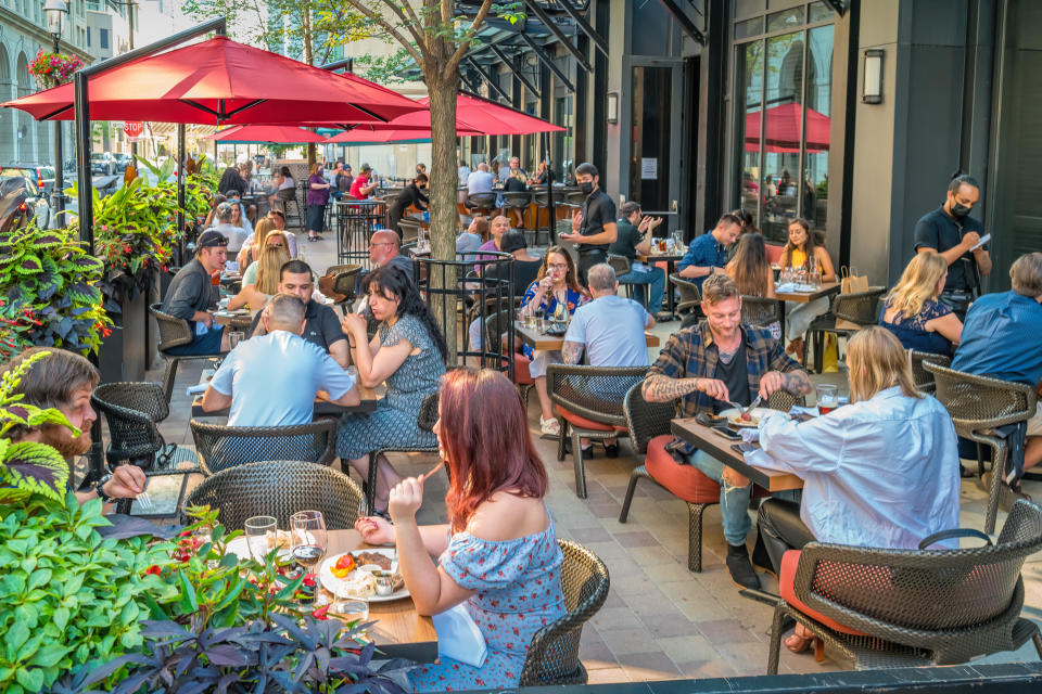 People dine on a restaurant patio in downtown Toronto Ontario Canada on a sunny evening.