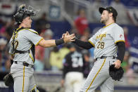 Pittsburgh Pirates relief pitcher Josh Fleming (28) and catcher Henry Davis (32) congratulate each other after the Pirates beat the Miami Marlins 7-2, during a baseball game, Friday, March 29, 2024, in Miami. (AP Photo/Wilfredo Lee)