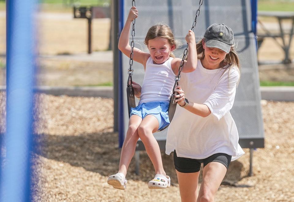 Jessica Foreman helps her daughter Charlee, 5, on a swing at Old Settlers Park.