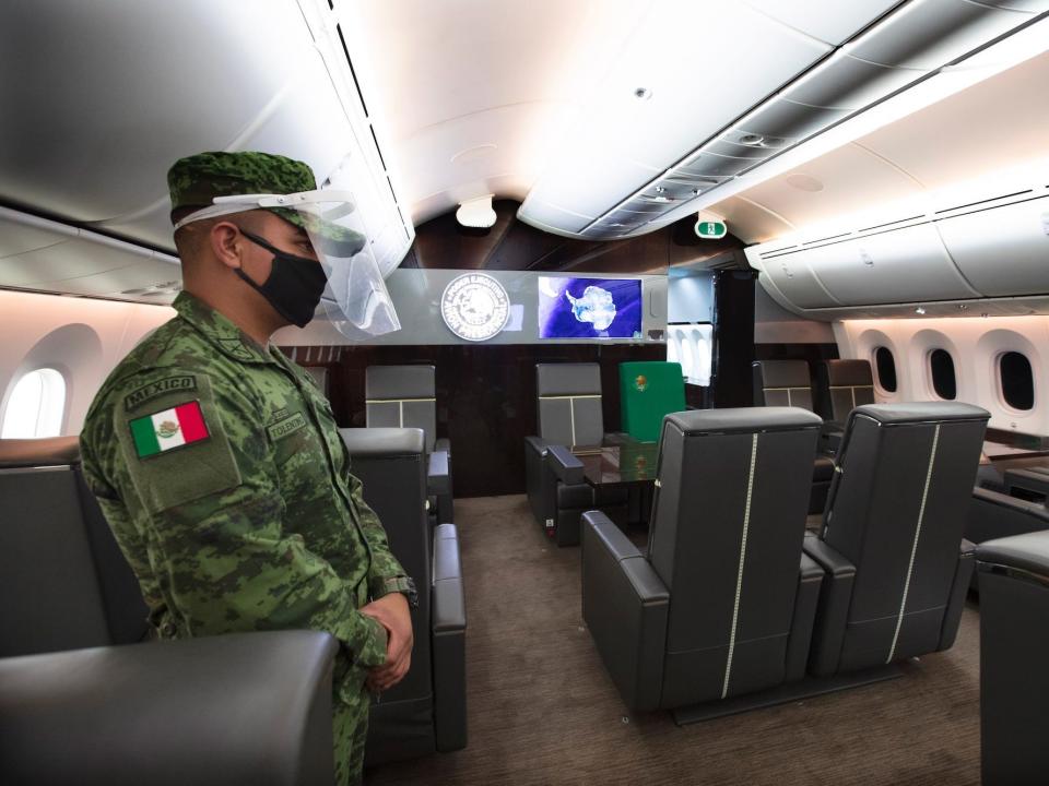 Inside Mexico's former VIP Boeing 787 complete with grey and green seats and wood-finished tables.