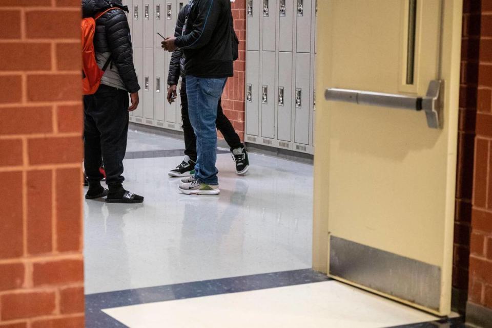 Tramaine Smith, right, speaks to a group of male students walking down a hallway at Hopewell High School on Nov. 22, 2021 in Huntersville. Smith is part of Titans Dads and Moms on Mission. The students are not pictured to protect their privacy.
